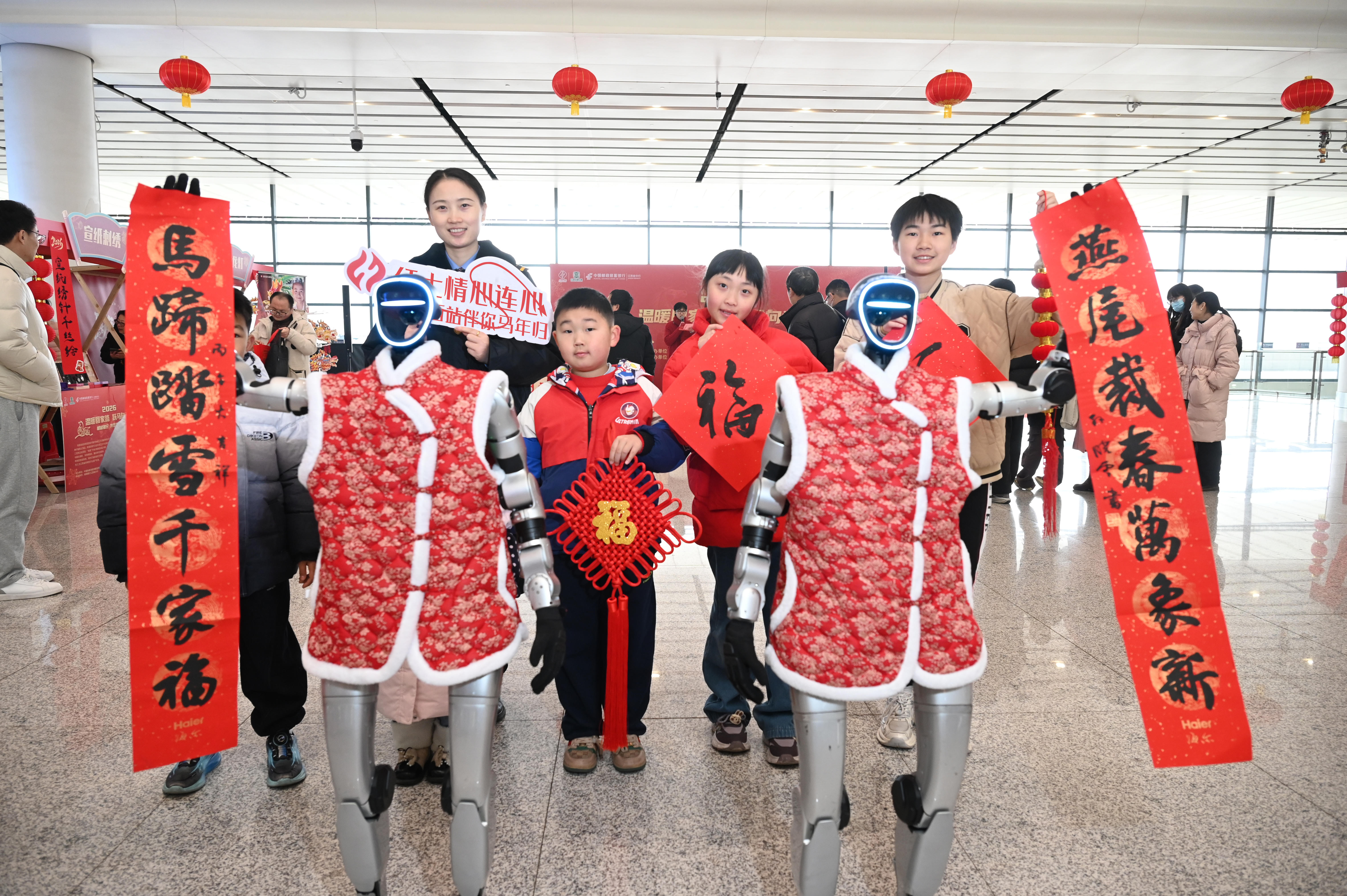 2026年2月10日,鐵路工作人員和旅客及機器人一起展示馬年春聯。鮑贛生 攝.jpg